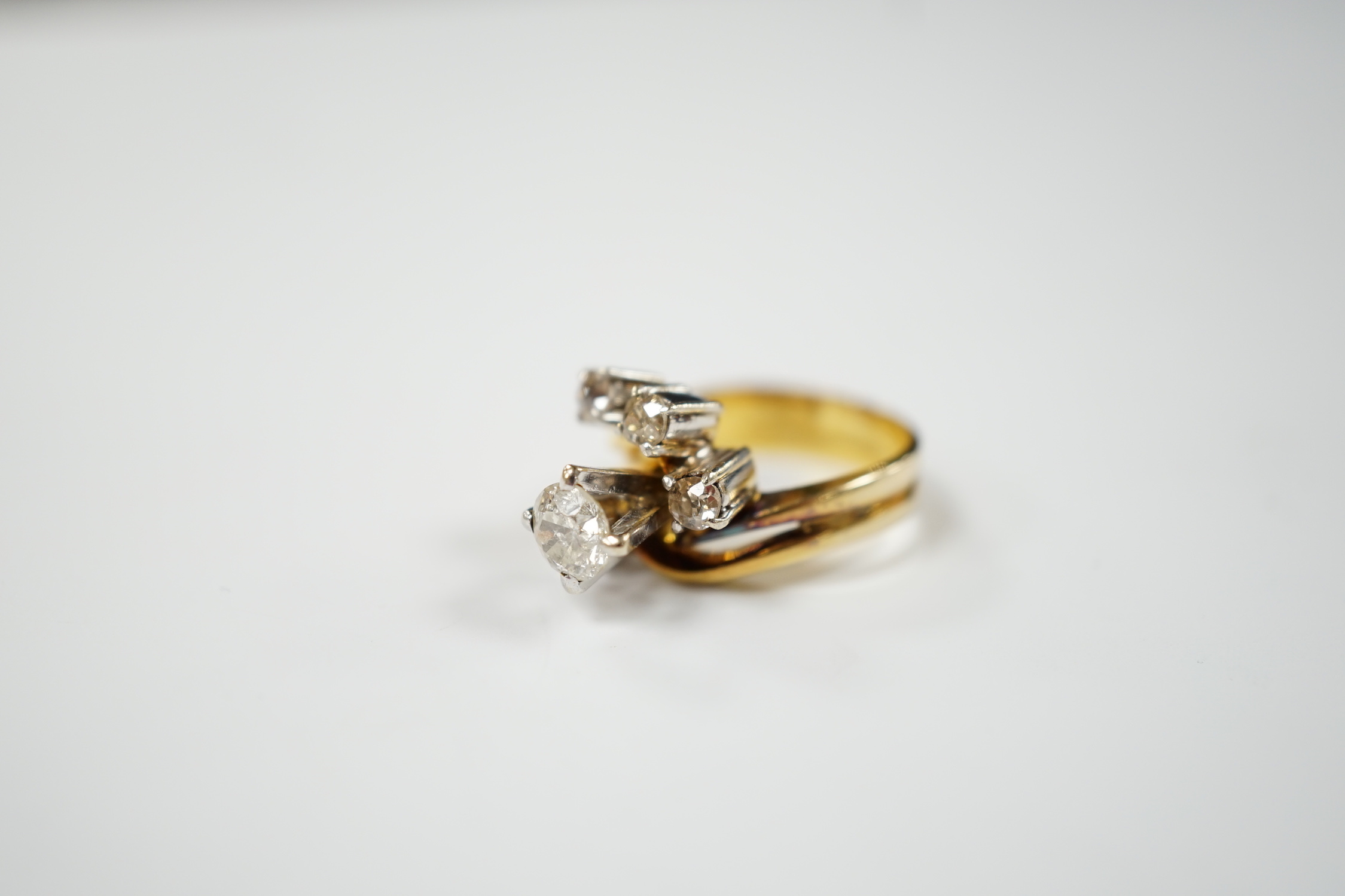 A yellow metal and graduated five stone diamond cluster set dress ring, in a raised setting, size J/K, gross weight 5.5 grams.